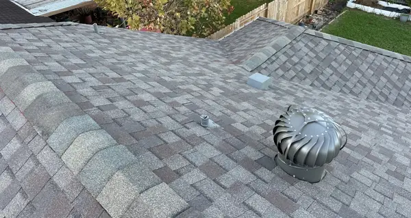 Charcoal laminate roof with reset turbine vent on a Houston home in 77092