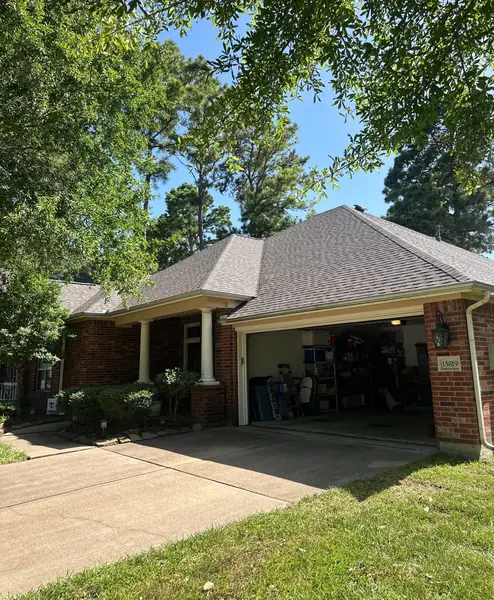 Front of the house showing the new gray architectural shingle roof and garage