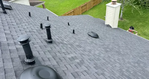 New charcoal shingle roof with replaced dome vents and chimney flashing in Houston 77064