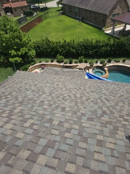 Main hip of a tan-brown shingle roof looking toward the backyard pool, Tomball