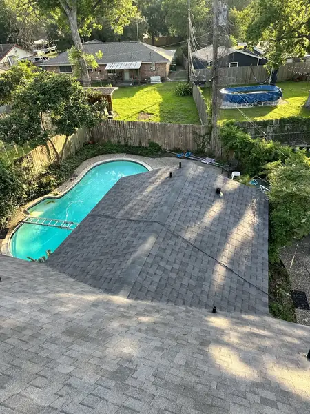 Rear slope of a replaced roof under trees in Houston