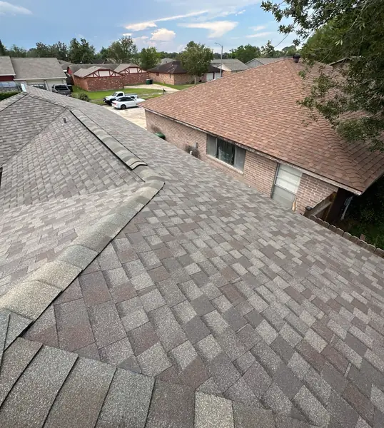 Weathered-gray laminate roof on a two-story Houston home in 77489