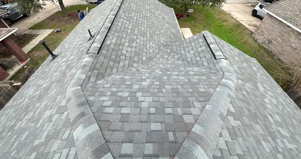Main ridge of a new gray roof with ridge vent in Humble TX