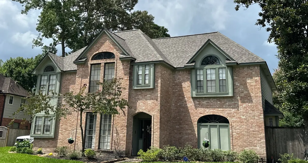 Front of the brick home with the completed roof, Kingwood 77345