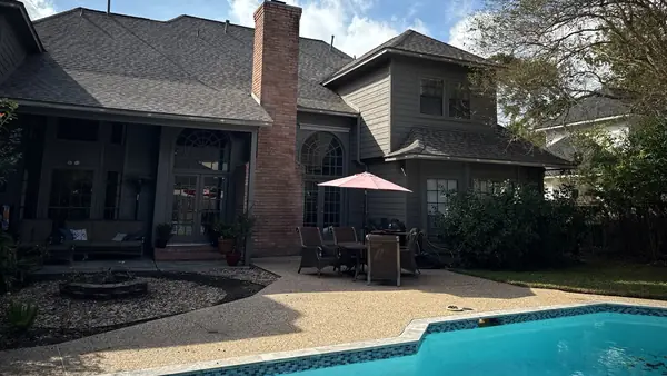 Rear of a two-story Kingwood home with the new roof above the pool