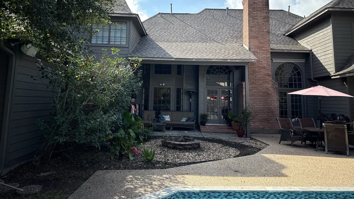 Rear elevation showing the chimney and new gray-brown shingles, Kingwood 77345