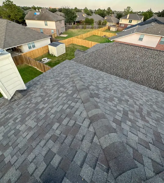 Hip and valley lines on the completed roof with neighboring homes beyond