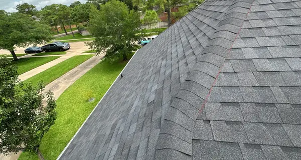 Hip of a new charcoal roof with the chimney, Cypress 77433