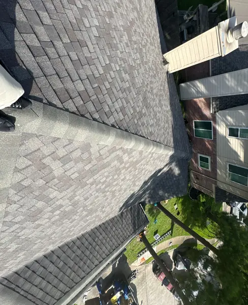 Hip ridge of a June 2025 roof replacement looking down to the driveway
