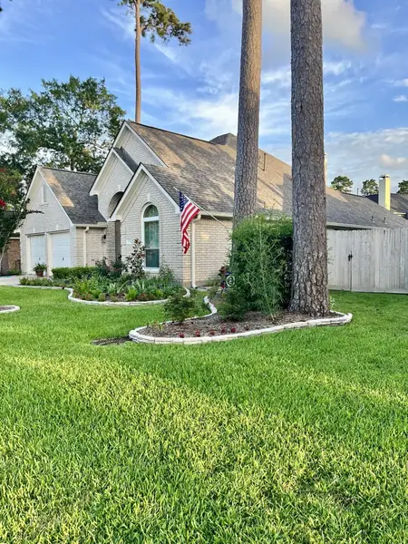Front of a single-story Cypress home after roof replacement, with a flag by the entry