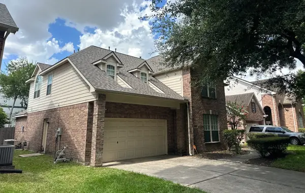 Garage side of a replaced roof with new front gutters in Houston