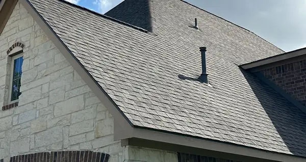 Close view of the new gray-brown shingles and the eave line