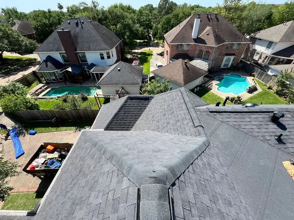 Weathered-gray laminate roof and brick chimney on an Energy Corridor home in Houston 77077