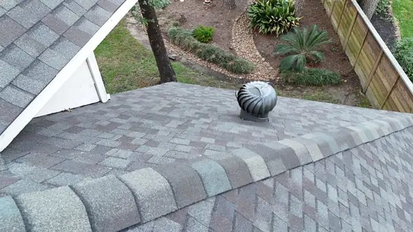 Charcoal laminate roof and brick chimney on a Kingwood home in 77345