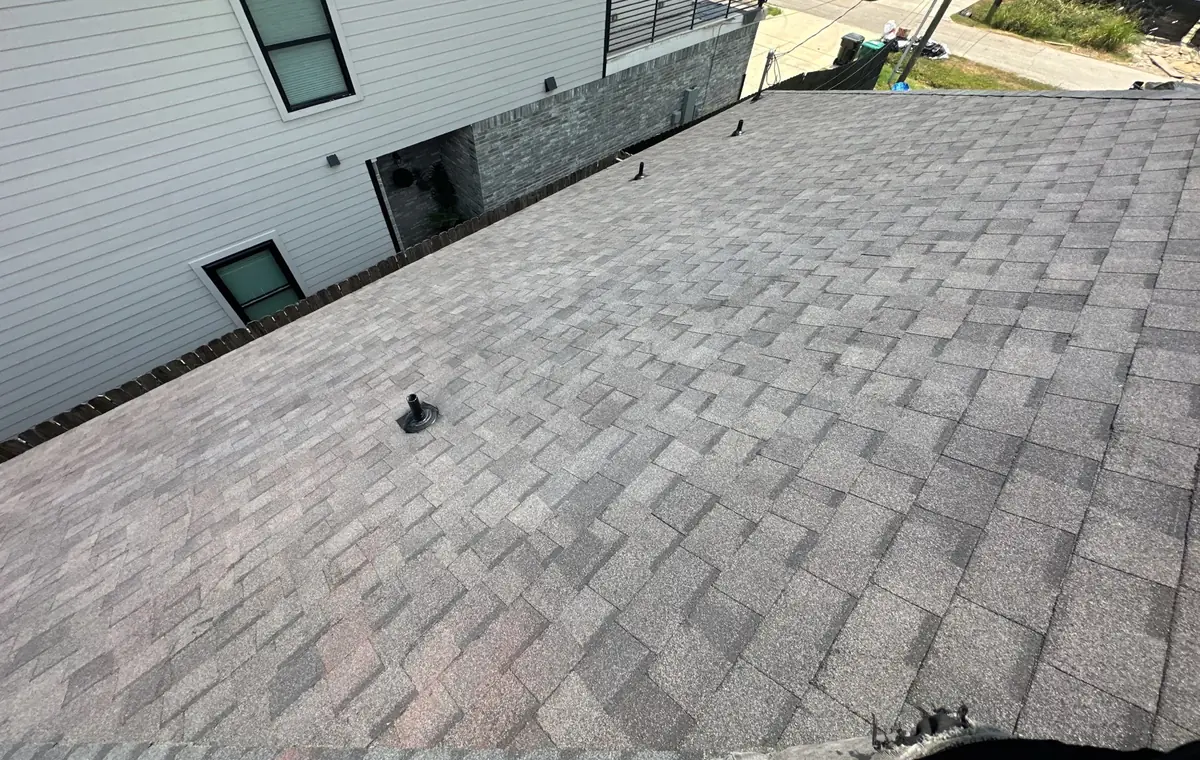 Moire Black architectural shingles on a south Houston roof, looking toward the street