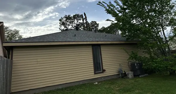 Rear of a one-story Houston home with a new shingle roof in Bear Creek