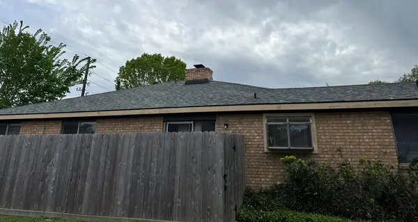 Side elevation of a June 2024 roof replacement over a wood fence