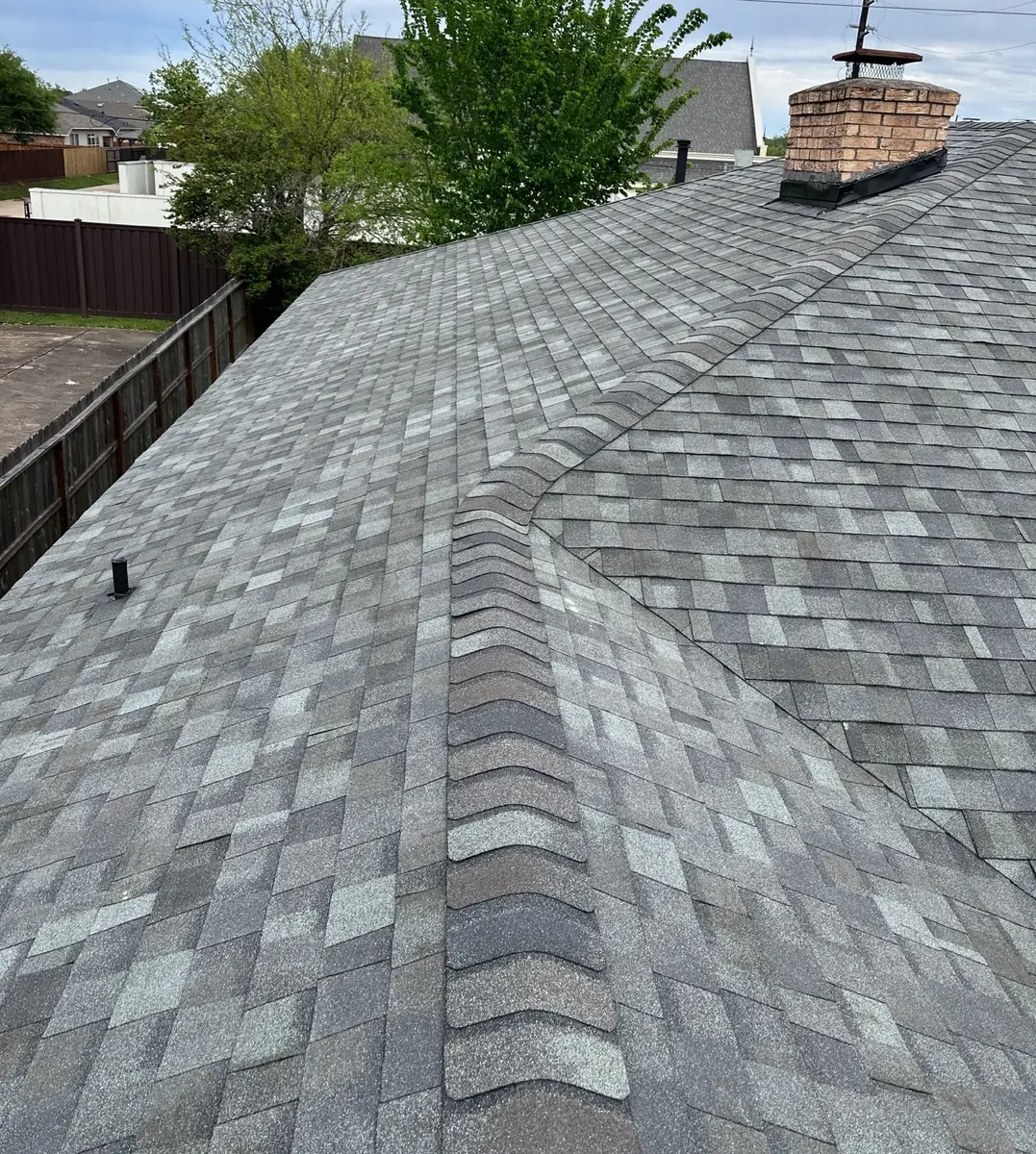Finished silver-gray laminate roof with brick chimney on a Houston home in 77084