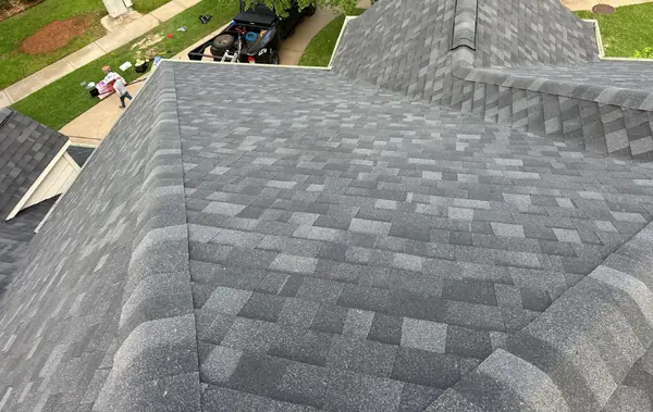 Gray shingle roof hips and cross gable on a Cypress home