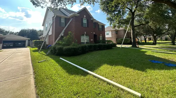 Side yard view of a two-story house with a new shingle roof