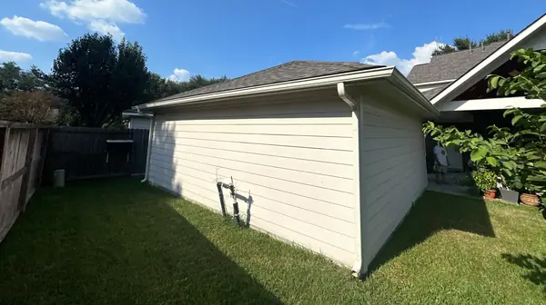 Rear elevation of a replaced roof and new gutters in northwest Houston