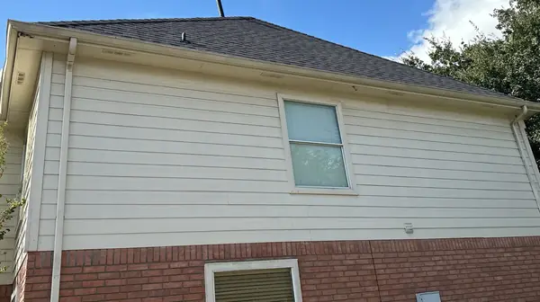 Siding side of a two-story house with a replaced roof