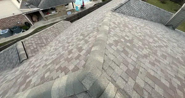 Hip caps of a new tan-brown roof in Cypress