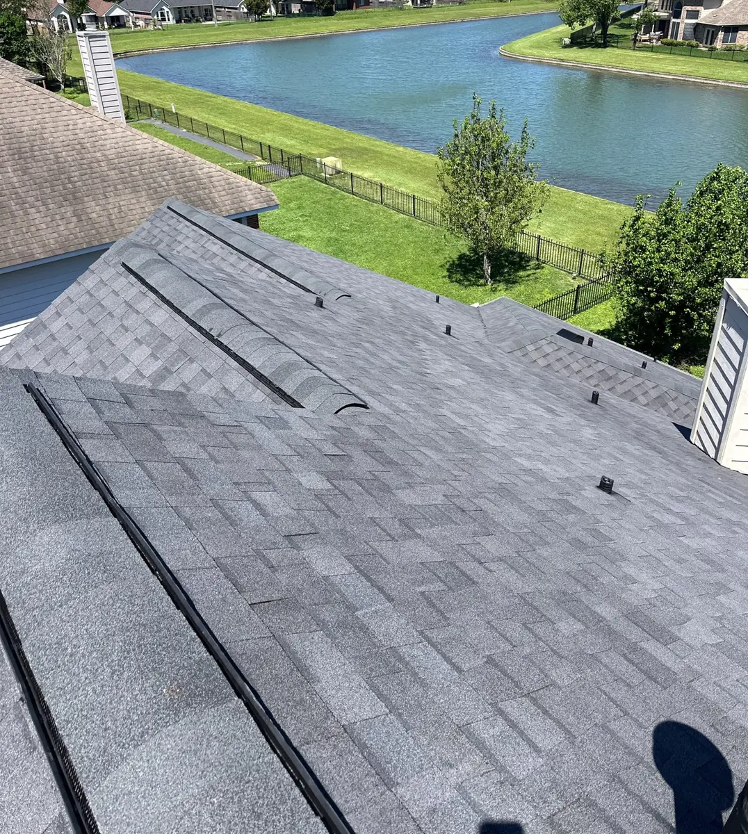 Weathered-gray laminate roof and brick chimney on a Copperfield home in Houston 77095