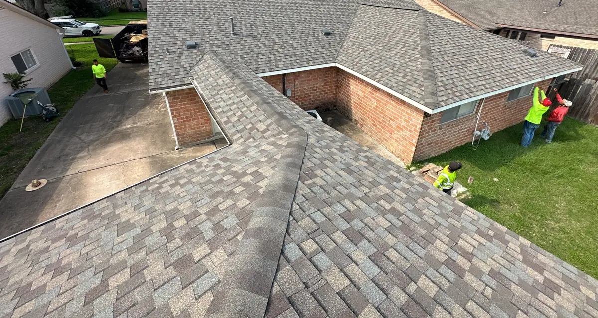 Rear slope of a two-story brick Katy home after roof replacement