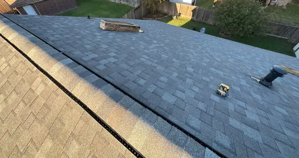 Shingle bundles staged on the ridge during a March 2026 roof replacement