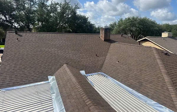 Hip lines of a Heather Blend shingle roof with the chimney in view