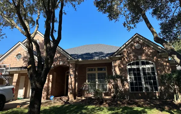 Front slope with fresh shingles under live oaks in Richmond, TX