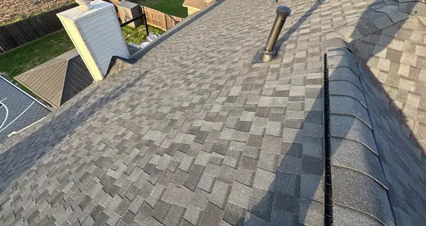 Hip and ridge caps of a new gray roof after storm damage, Cypress