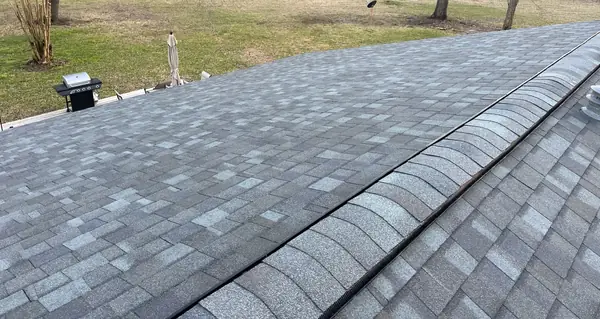New ridge vent under the caps on a storm-replaced roof in Conroe