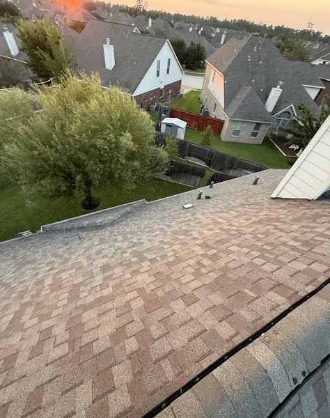 Hip and ridge caps of a new tan-brown roof in Tomball