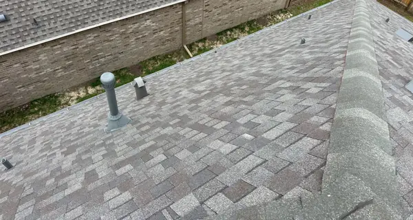 Hip lines of a new gray roof in Katy after storm damage